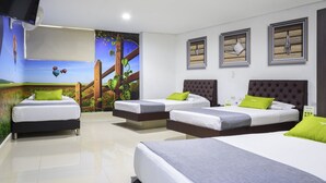 Una habitación de hotel con tres camas, un mural de un paisaje y un televisor montado en la pared.
