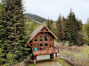 A cabin with a wooden exterior, large windows, and a balcony.