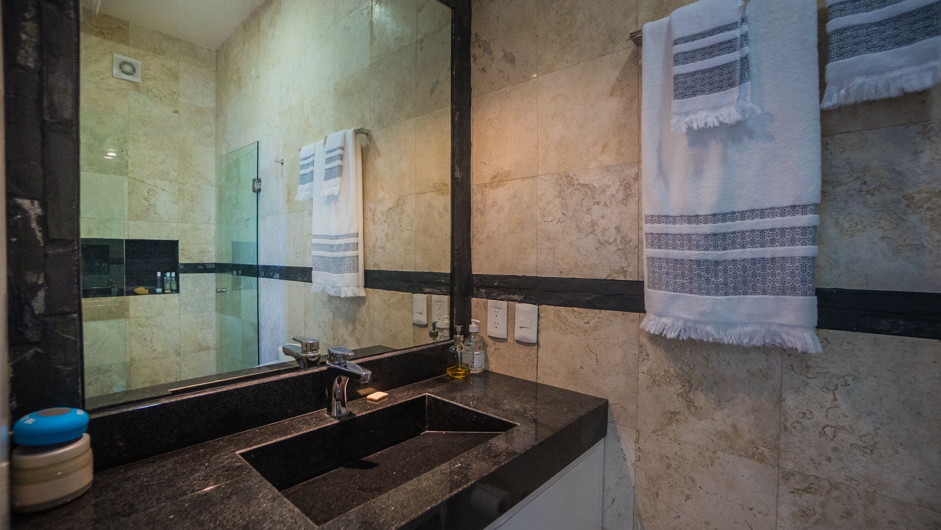 Une salle de bain équipée d’un lavabo, d’un miroir et de porte-serviettes.