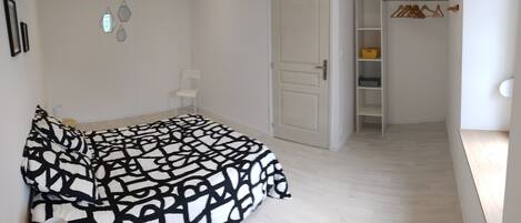Quarto com cama, guarda-roupa e armário.