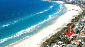 Vista aérea de una zona costera con playa y edificios residenciales cercanos.