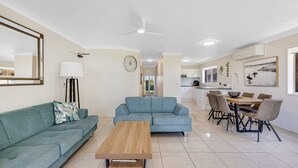 Una sala moderna con sofá, mesa de centro y comedor con sillas y mesa.