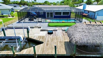 Enjoy a refreshing dip in the backyard pool surrounded by a deck and a shaded area.