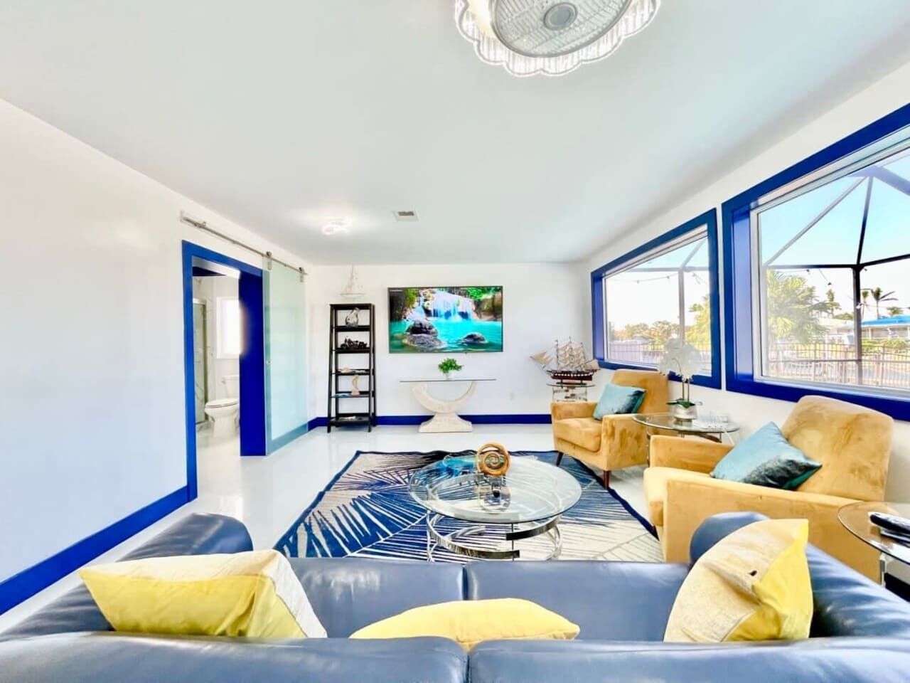 A modern living room with a blue sofa, a coffee table, and a television.