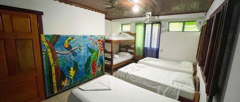 A room with bunk beds, a ceiling fan, and a mural on the wall.