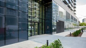 A modern building with large glass windows and a clean, tiled walkway. - Modern Studio | Parking | Air Conditioning | Close to Expo XXI (Warszawa)