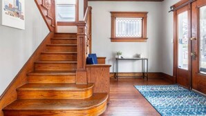 A wooden staircase leading to a landing with a small table and a window.