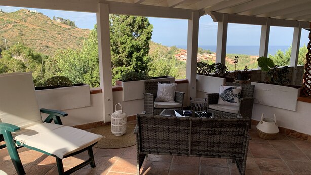 A covered outdoor seating area with wicker furniture and a view of the sea. - Eden Rock sea View  (Eden Rock)