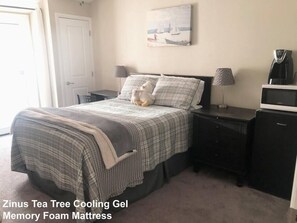 A bedroom with a bed, bedside tables, a coffee maker, and a painting on the wall. - Comfy Suite Near ASU, Extra Clean and Private! (Tempe)