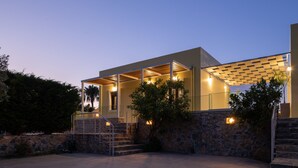 A modern house with a stone exterior, a covered porch, and a staircase leading to the entrance. - Mela Villa Lemon with Private Pool, Eco Friendly (ΡΕΘΥΜΝΟ)