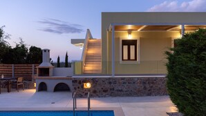A modern outdoor pool area with a stone wall, a barbecue grill, and a staircase leading to a second level. - Mela Villa Lemon with Private Pool, Eco Friendly (ΡΕΘΥΜΝΟ)