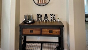 A kitchen area with a black metal cart labeled "BAR" and a sign above it that reads "GILBERT Est. 1920 Elevation 1237 ft". - Casa Del Sol Gilbert, Arizona Heated Pool & Hot Tub (Gilbert)
