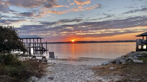 A beach with a wooden pier, a chair, and a small shelter. - Luxury heated pool & spa home, pool bar, steps to the beach & two master suites! (St. Augustine)