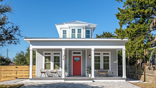 A modern house with a red door, two covered porches, and a small front yard. - Luxury heated pool & spa home, pool bar, steps to the beach & two master suites! (St. Augustine)