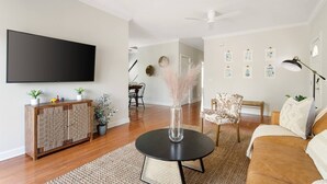 A living room with a flat-screen TV, a round coffee table, a sofa, a cabinet, and a chair. - ✰ MARSH VIEW - CHARMING 3BR/2.5BA - BIKES/KAYAKS ✰ (North Charleston)