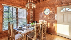 A wooden dining room with a table set for four, a chandelier, and a welcome sign on the wall. - Pet friendly,5min2Dollywood,3 kings+loft,Game Room (Pigeon Forge)