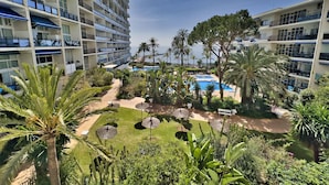 A hotel with multiple floors, a swimming pool, and lush greenery. - Skol 521 - Fantastic Beachfront Studio Holiday Home (Marbella)