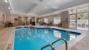 An indoor swimming pool with clear water, a pool lift, and a seating area with chairs. - Best Western Plus Rumford Falls (Rumford)