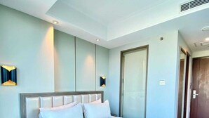 A modern hotel room with a large bed, a bedside table, a wardrobe, and a bathroom door. - Arthama Hotel Tanah Abang Jakarta (Jakarta)