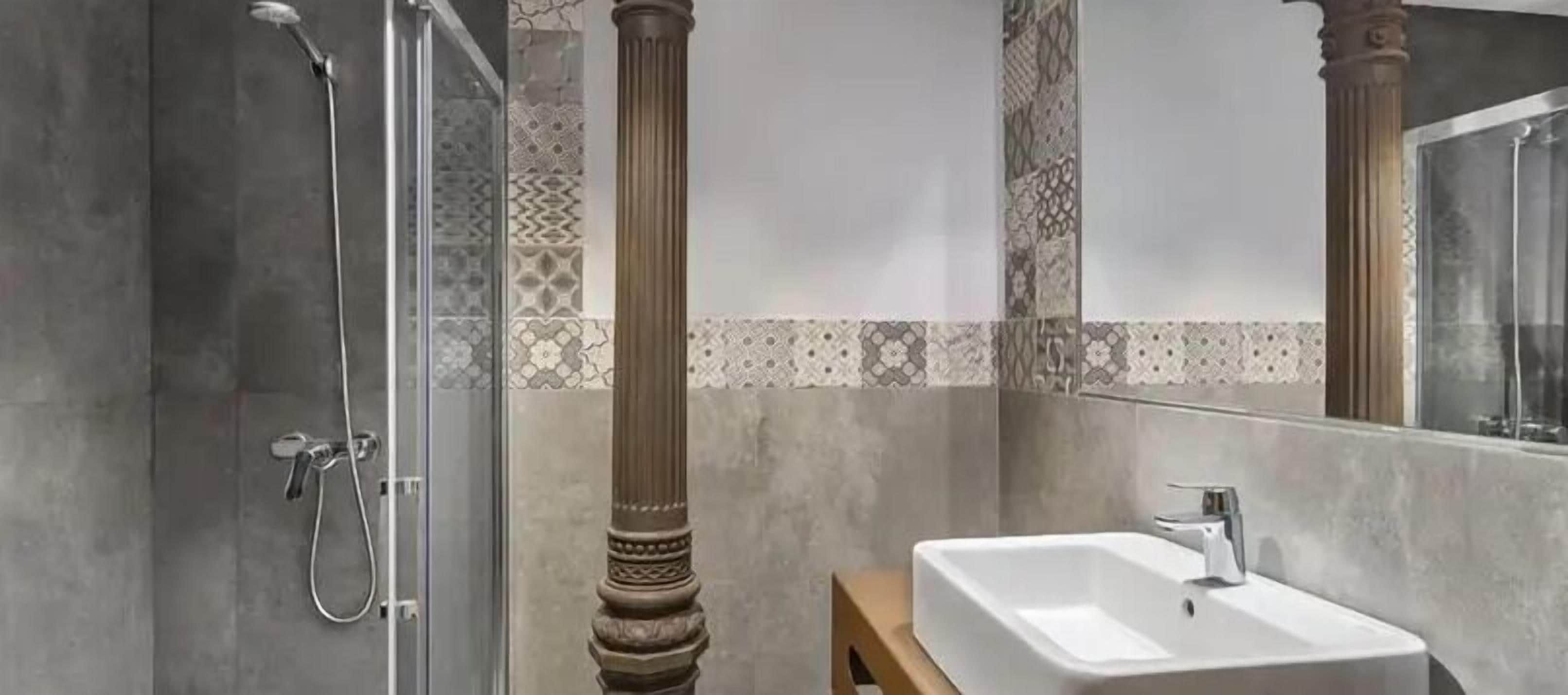 A bathroom with a shower, a sink, and a mirror.