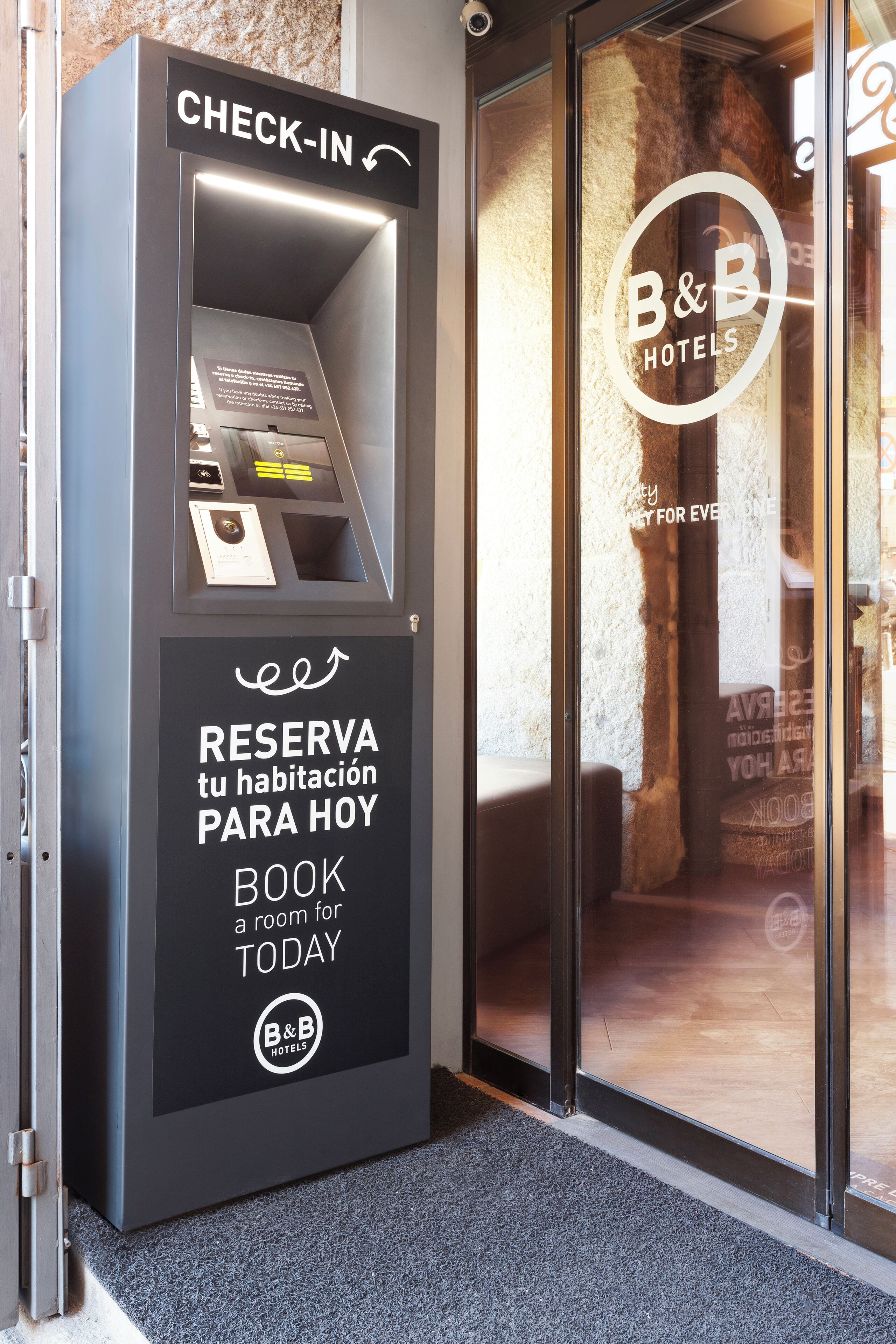 A B&B hotel check-in kiosk with a glass door and a sign indicating room reservation for today.