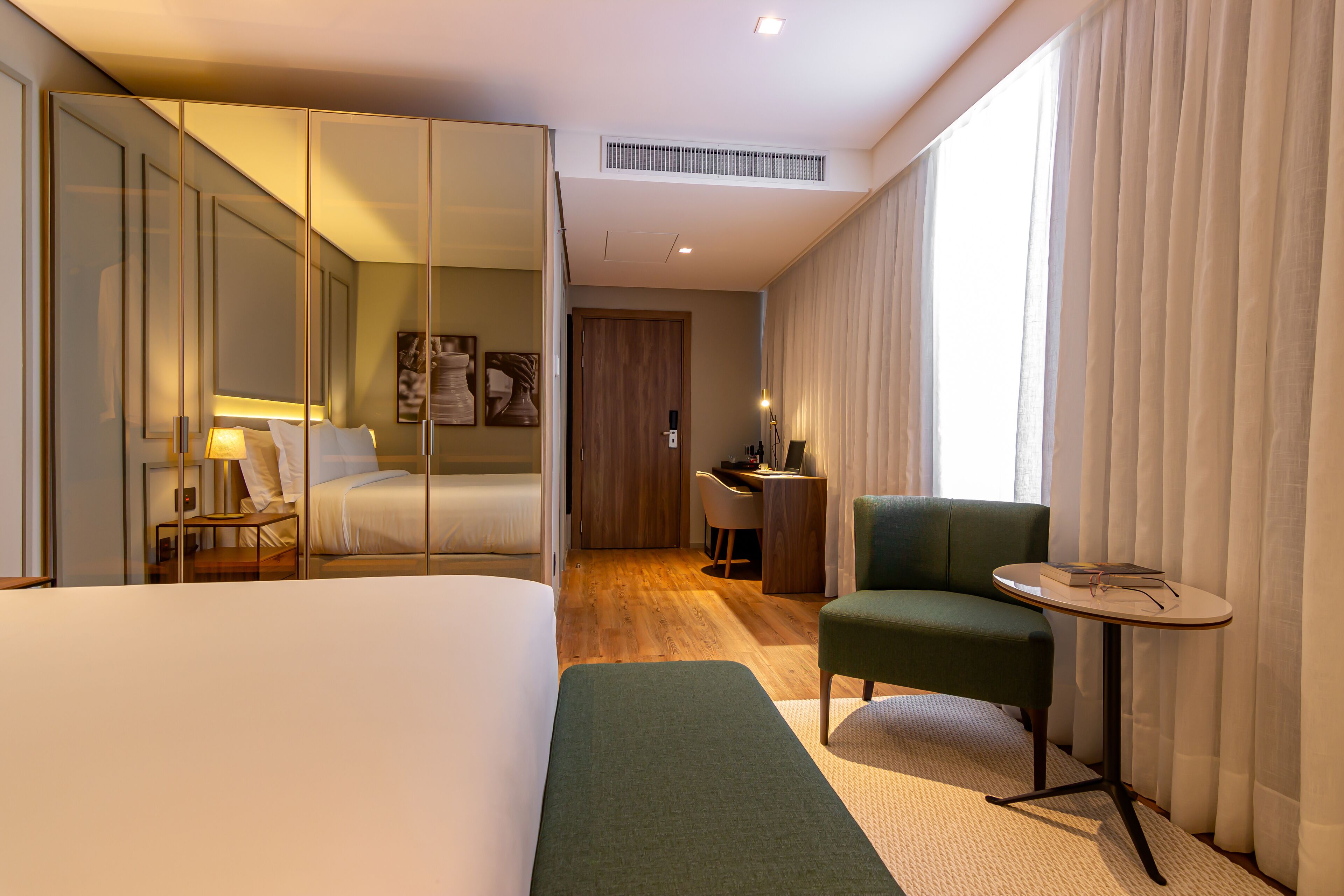 Una habitación de hotel con una cama grande, un escritorio, una silla y una mesita.