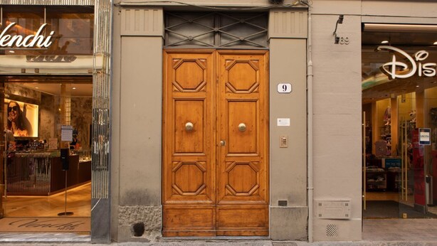 Ein Gebäude mit einer Holztür, einer gut sichtbaren Nummer 9 an der Wand und einem Schaufenster mit Disney-Logo.