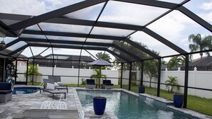 En utomhuspool med tak, utrustad med solstolar och en pergola.