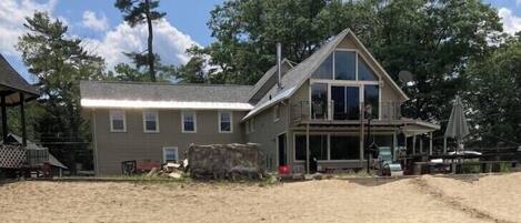A two-story house with a large front porch, a garage, and a covered outdoor area.