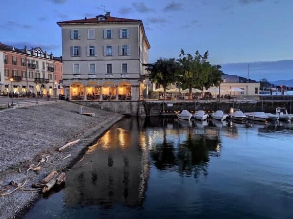 A waterfront building with multiple windows and a restaurant on the ground floor.