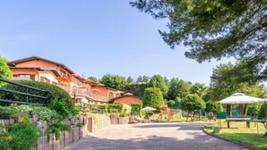 A paved pathway leading to a residential area with houses, a playground, and a gazebo. - Residenza Agrifoglio by Interhome (Luino)
