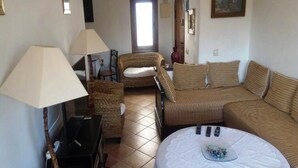 Ein gemütliches Wohnzimmer mit Sofa, Sessel und rundem Tisch mit dekorativer Dekoration.