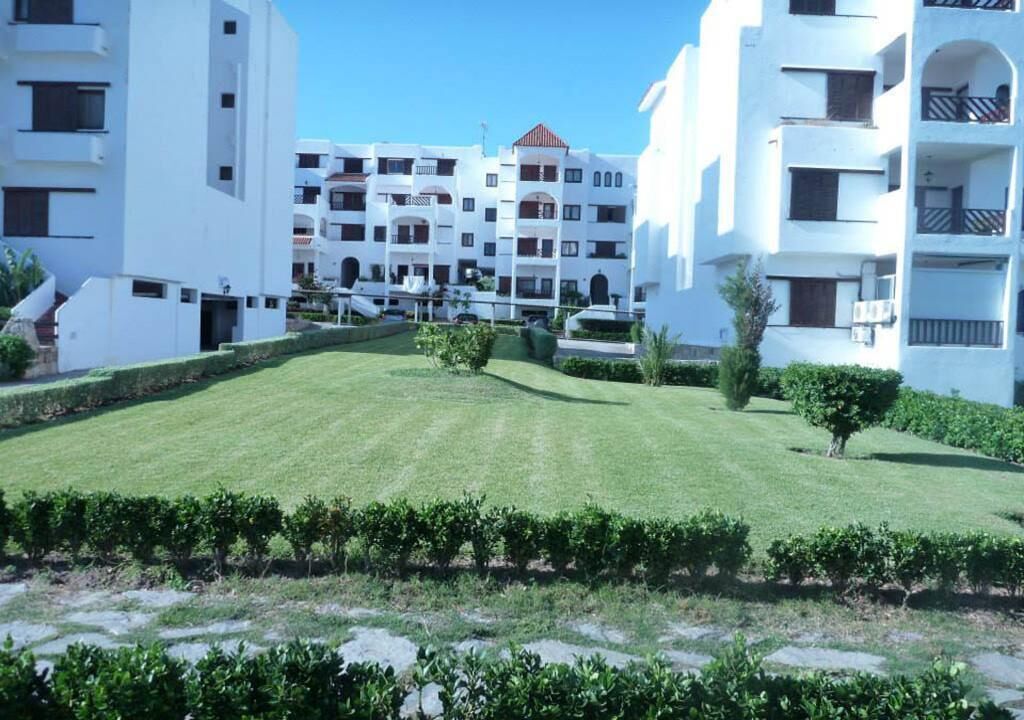 Un bâtiment moderne doté de nombreux balcons et d’une pelouse bien entretenue.