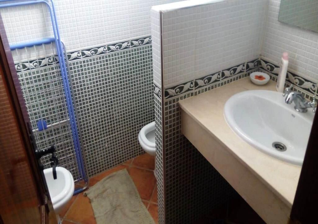 A bathroom with a toilet, bidet, and sink.