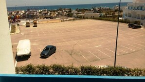 A parking lot with several cars and a covered vehicle. - Residence Smir Park Beach 1672 (Mdiq)