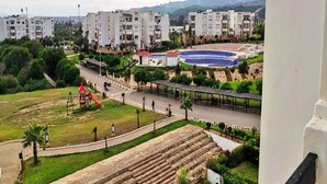 A residential area with modern apartment buildings, a playground, and a swimming pool. - Residence Playa Del Pacha 4858 (Mdiq)