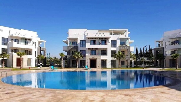 Un edificio moderno con una piscina delantera.