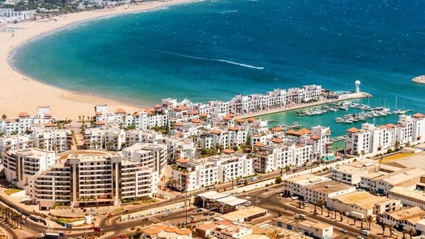 A coastal cityscape with a marina, residential buildings, and a beach. - Apartment El Farah 10 min from the beach 4622 (Agadir)
