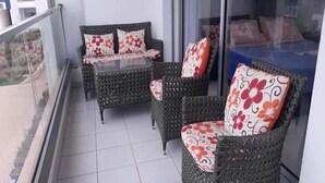 A balcony with wicker furniture and floral cushions. - Residence Adan Beach 4790 (Aourir)