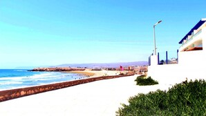 Una passeggiata costiera con vista libera sul mare, un lampione e un edificio moderno con un balcone.