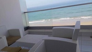 A balcony with white wicker furniture and a view of the beach. - Residence Adan Beach 4803 (Aourir)