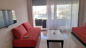 A modern living room with a sofa set, a coffee table, and a TV mounted on the wall.
