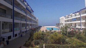 Ett hotell med flera våningar, en utomhuspool och frodig grönska.