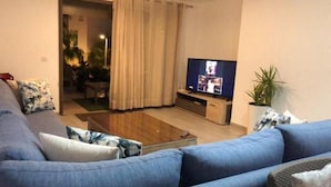 Ett vardagsrum med en soffa, ett soffbord och en tv.