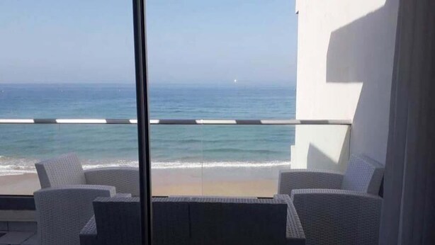 A balcony with wicker furniture overlooking a beach. - Residence Adan Beach 4802 (Aourir)
