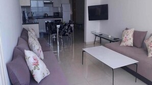 A modern living room with a sofa set, a coffee table, and a TV mounted on the wall. - Residence Adan Beach 4802 (Aourir)