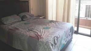 Une chambre à coucher avec un lit, des rideaux et une vue sur l’extérieur.