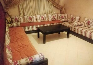 A living room with a sofa set, a coffee table, and curtains. - Residence Caprice Palace 4846 (Marrakech)
