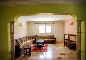 Una sala de estar con un sofá, una mesita de centro y un tapete estampado.