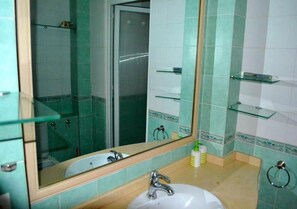 A bathroom with a sink, mirror, and glass shelves. - Marina Agadir Residence 4903 (Agadir)